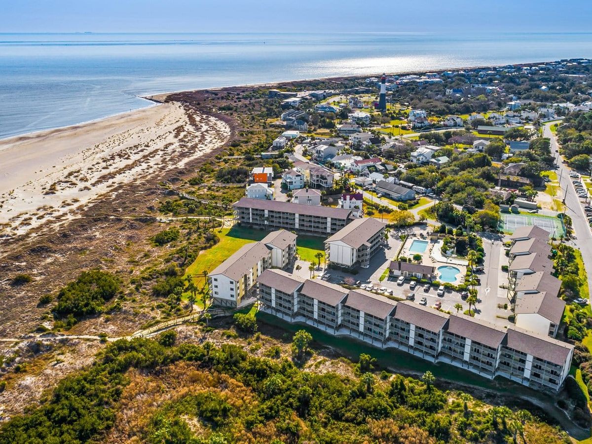 An aerial view of Tybee Island shows sandy beaches, quiet neighborhoods, and a beautiful stretch of coastline. You can see the dunes and water meeting under the bright sun. It’s a peaceful coastal scene that feels calm and inviting.
