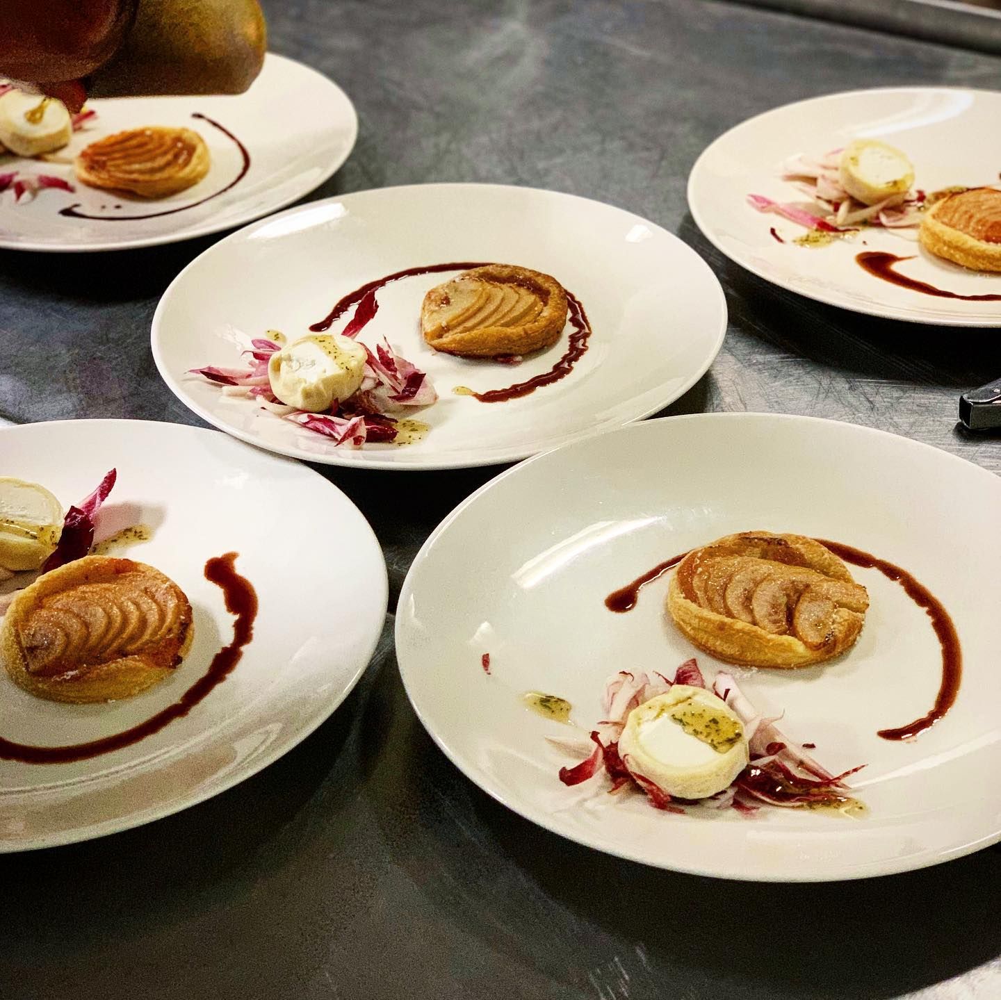 A beautifully plated lamb dish topped with herbs and served with chickpeas, vegetables, and crisp garnish. The presentation shows the attention to detail found in upscale restaurants. It’s a great example of how chefs turn simple ingredients into elegant meals.