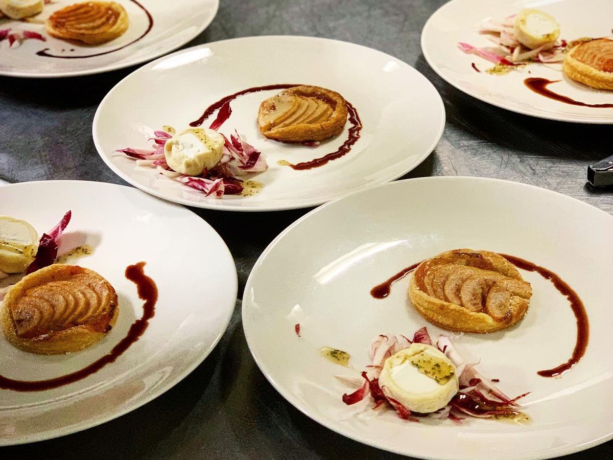 A beautifully plated lamb dish topped with herbs and served with chickpeas, vegetables, and crisp garnish. The presentation shows the attention to detail found in upscale restaurants. It’s a great example of how chefs turn simple ingredients into elegant meals.