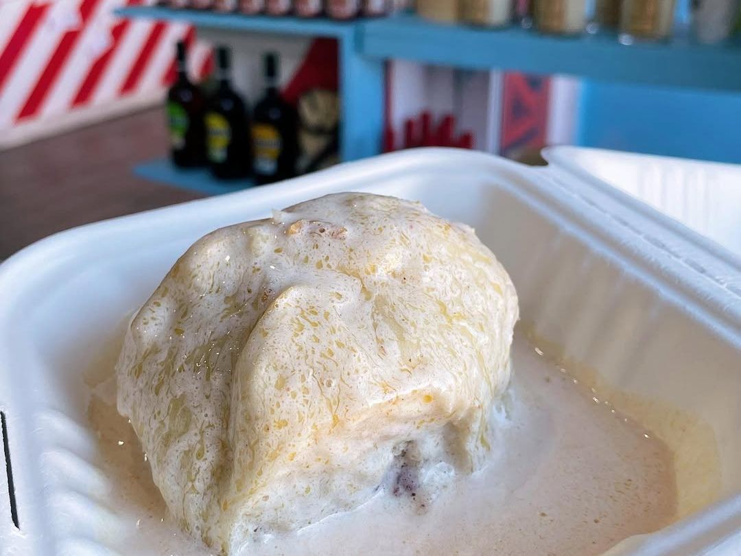 A warm serving of Guava Duff covered in creamy sauce, a traditional Bahamian dessert known for its rich flavor and soft texture. A true island favorite that brings sweet comfort in every bite.