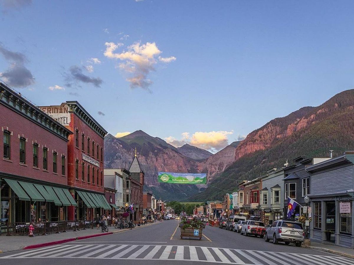 A charming view of downtown Telluride lined with historic brick buildings, local shops, and towering mountains in the distance. A perfect mix of small-town charm and alpine beauty.