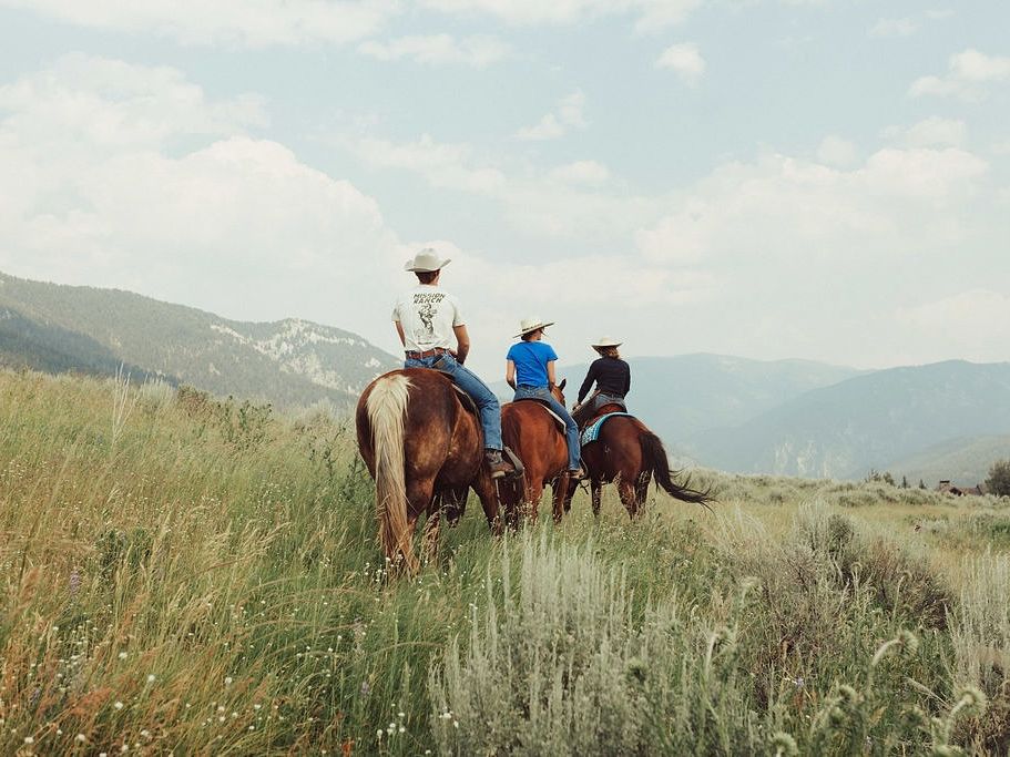 Riders on horseback explore open meadows with rolling mountains in the distance. Big Sky’s horseback trails offer a true taste of Montana’s western spirit.
