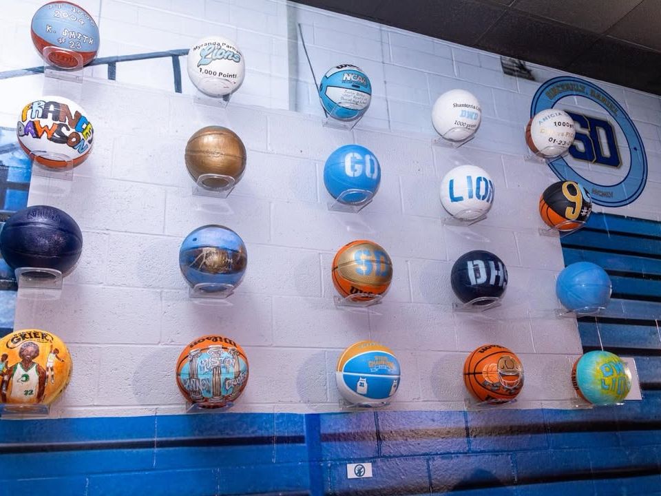 A colorful wall of basketballs honors local sports legends inside a community museum. Each ball tells a story, making it a fun stop for sports fans and history buffs alike.