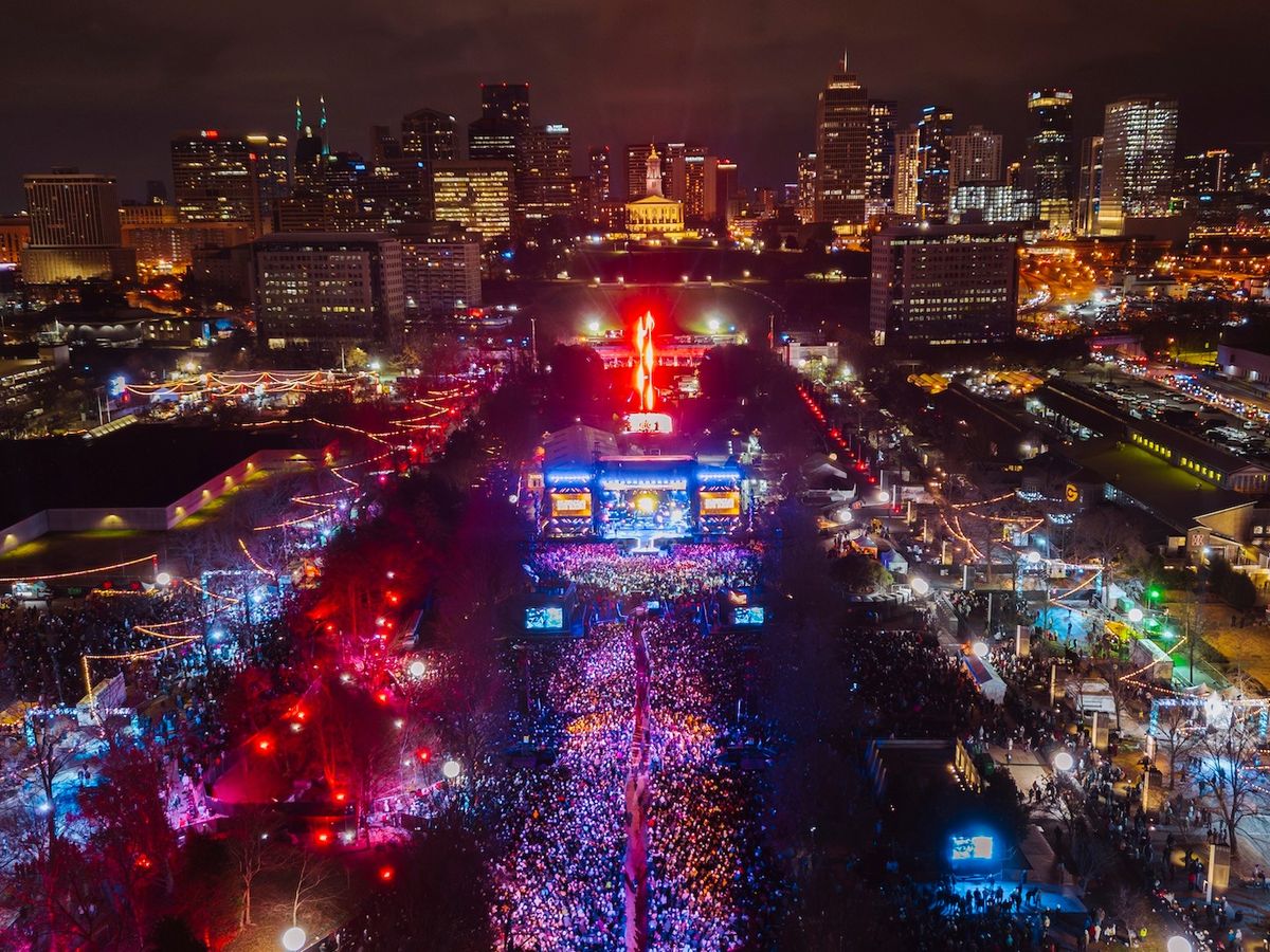 An aerial view of Nashville’s New Year’s Eve Big Bash showing thousands of people packed along Broadway and the main stage. The city skyline glows as live music and lights fill the streets.