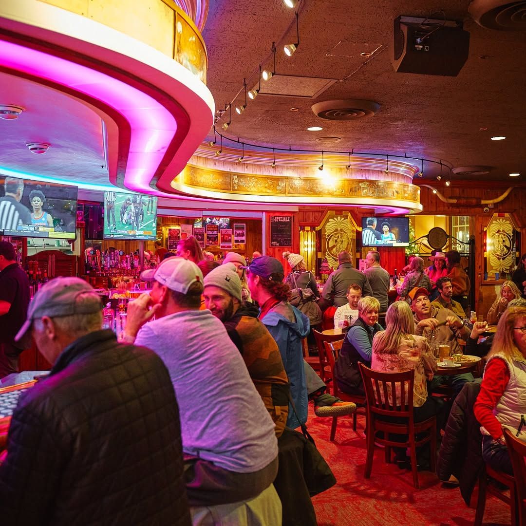 Guests gather around the bar at The Silver Dollar Showroom, enjoying drinks and live sports in a warm, vintage setting. This classic Jackson Hole venue blends old-west charm with live entertainment and social energy.