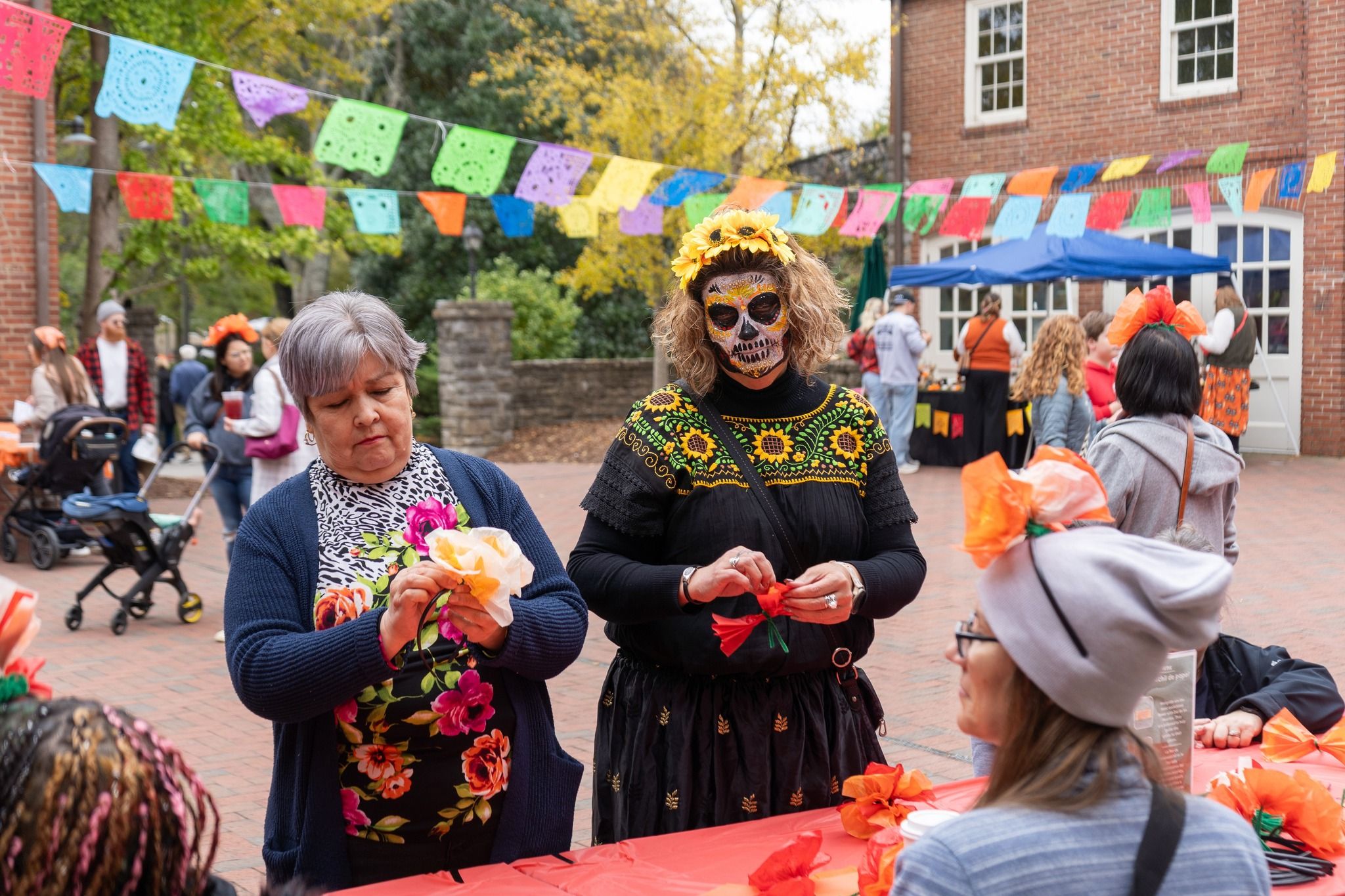 Crowds gather under rows of festival tents, enjoying drinks, food, and sunny weather at the Tennessee Beer, Wine, and Shine Festival. People chat, taste samples, and explore local vendors under the big shade trees. The whole scene has a lively, friendly vibe perfect for a fall day out.