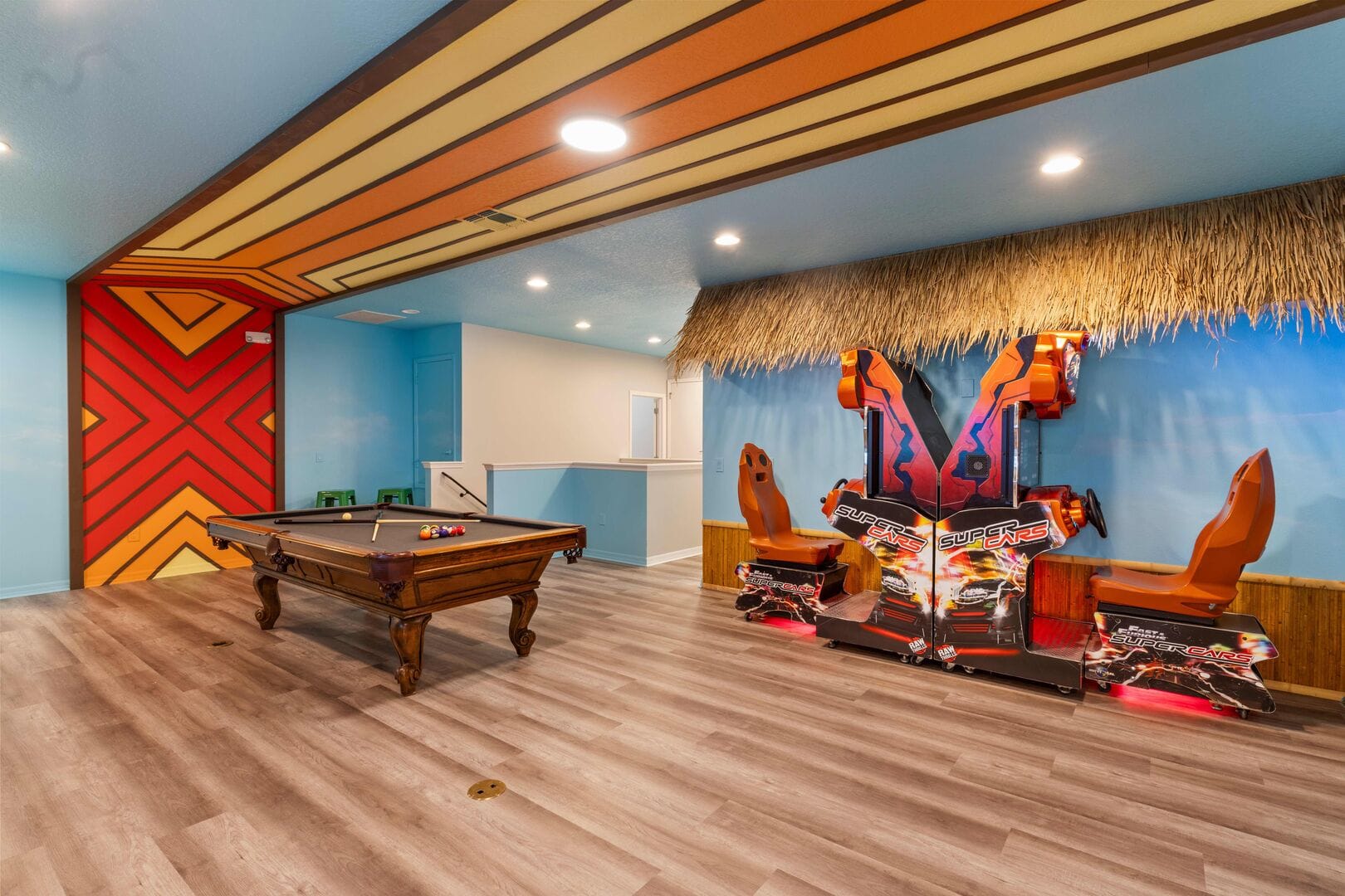 Game room area with back to back super cars game, retro wall design, and pool table