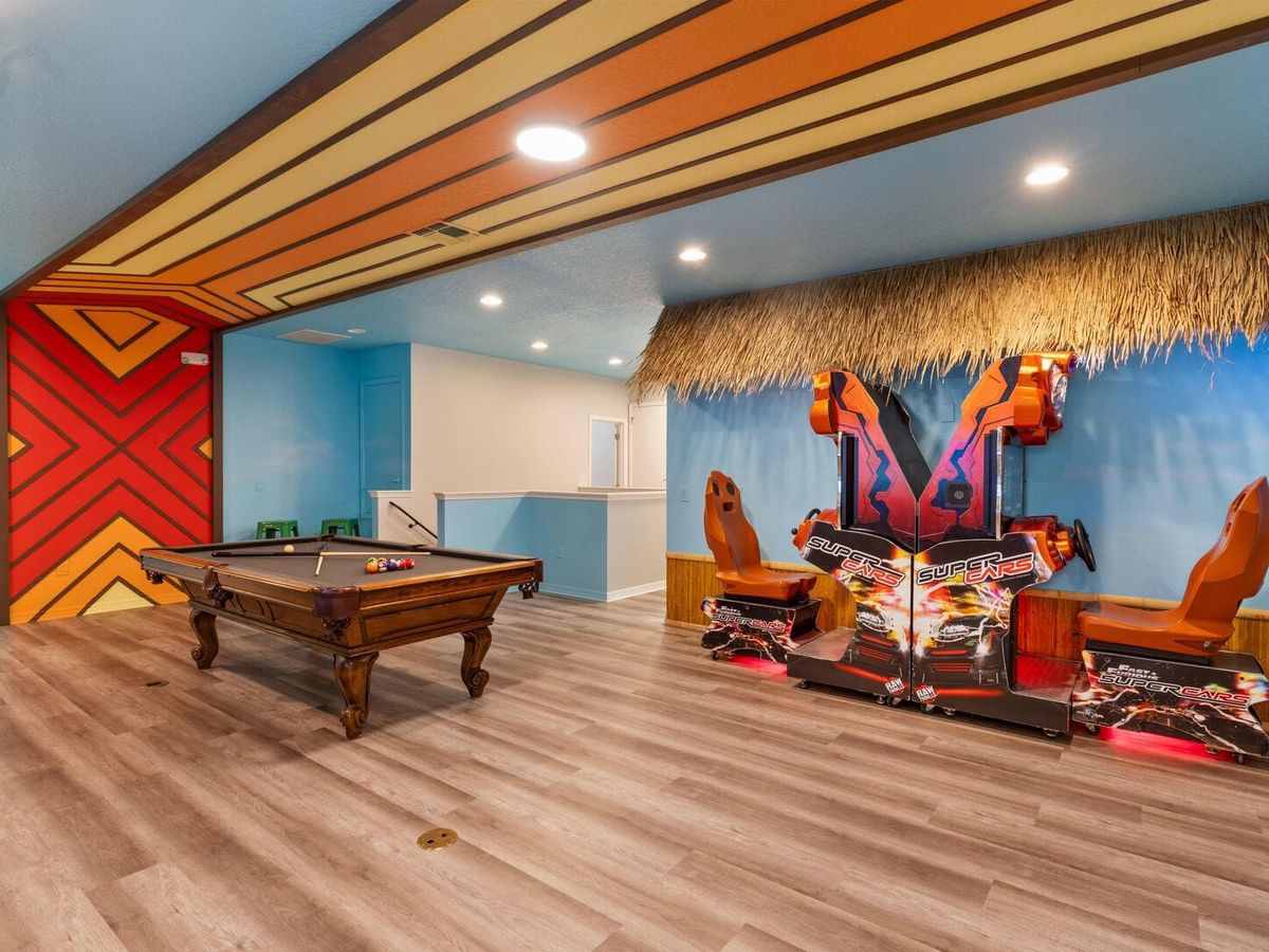 Game room area with back to back super cars game, retro wall design, and pool table