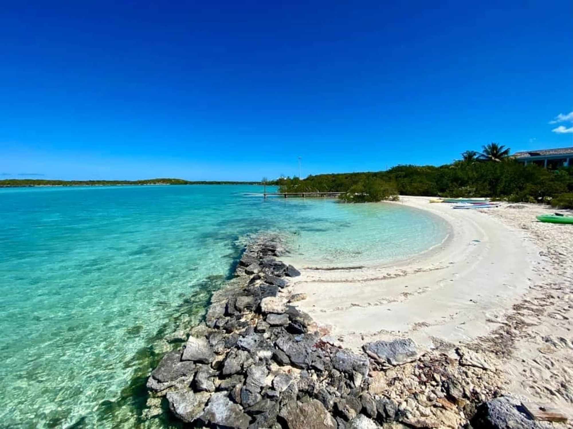 A peaceful beach in the Bahamas with soft white sand, calm turquoise water, and palm trees swaying in the breeze. The scene feels like a dream getaway perfect for relaxing and soaking up island vibes.