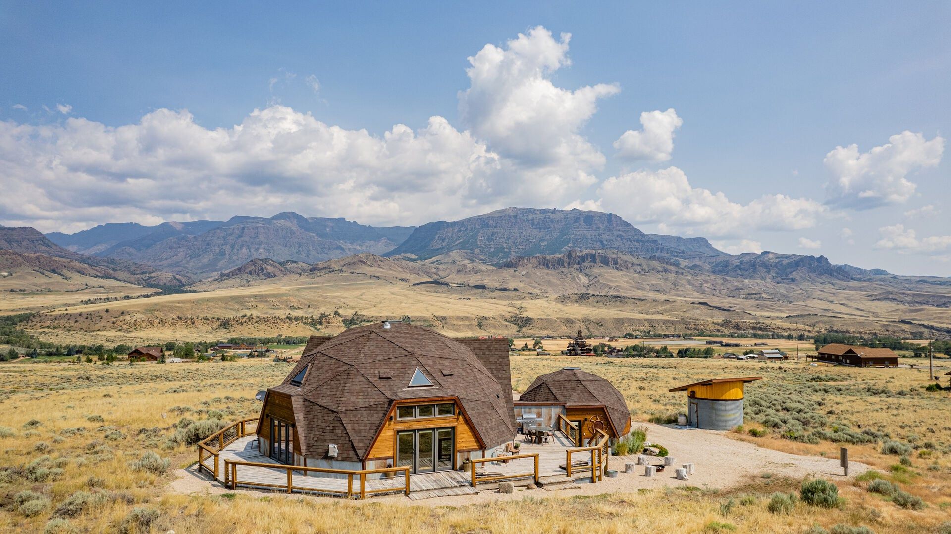 Dome House sits in a wide Wyoming landscape surrounded by open fields and rugged mountain views near Cody. Its unique dome-style design and quiet setting give guests a peaceful base for a Western mountain getaway.