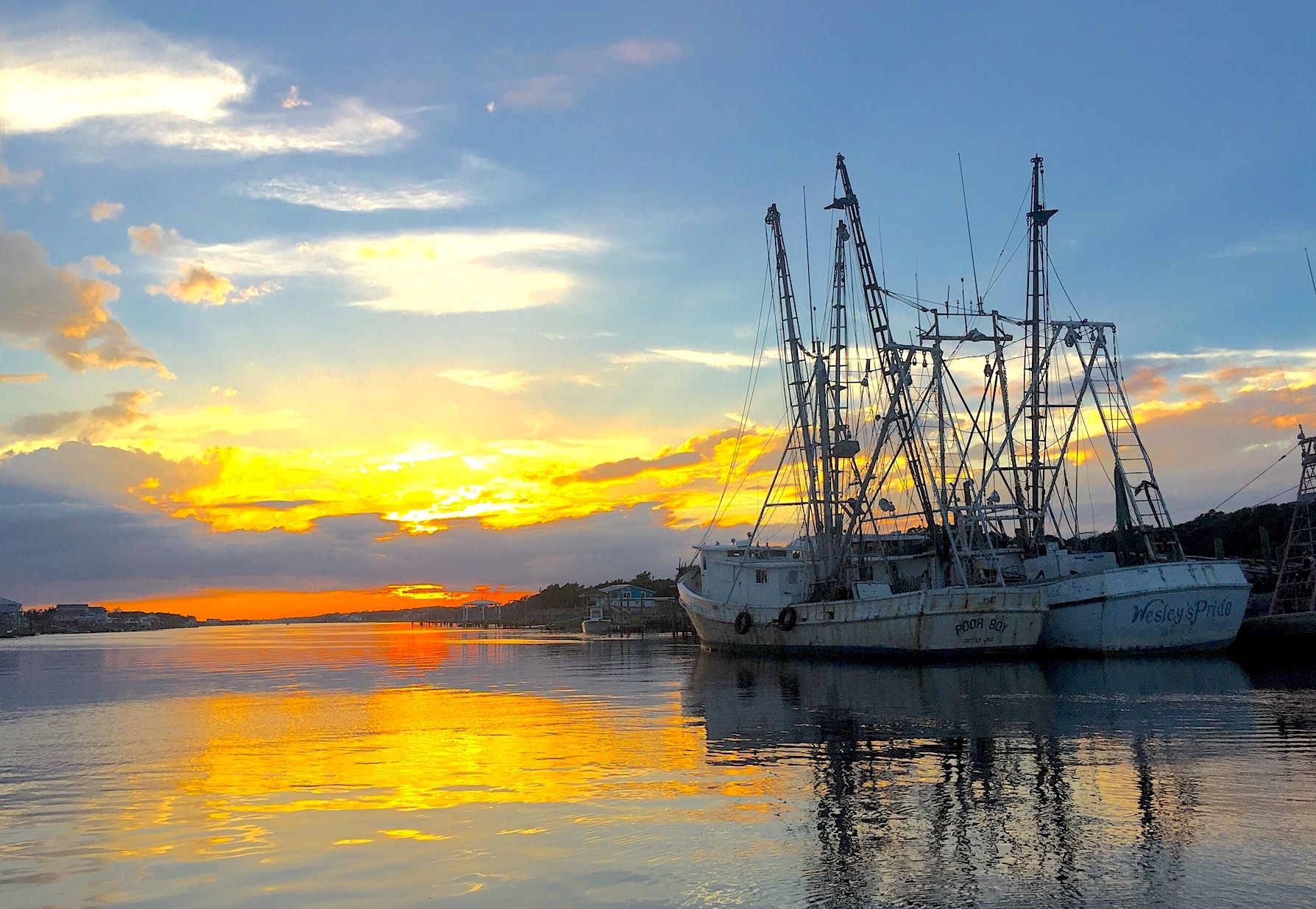 Sunset over Holden Beach with fishing boats in the water 