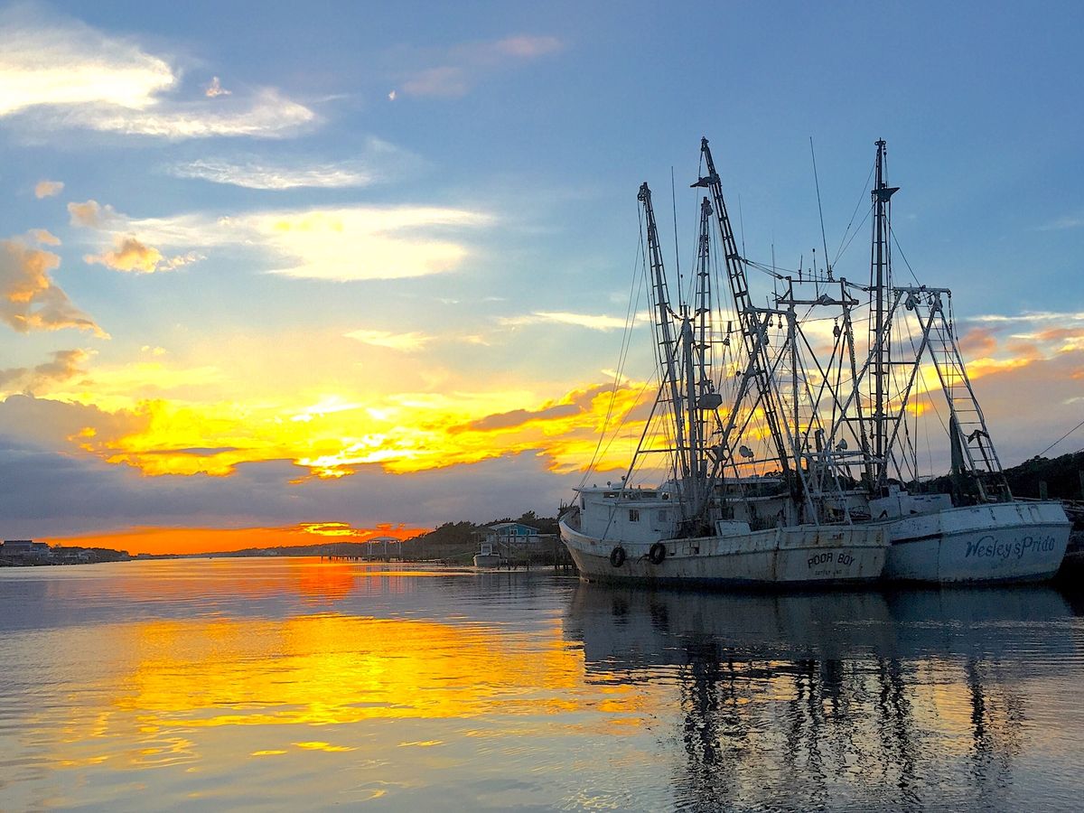 Sunset over Holden Beach with fishing boats in the water
