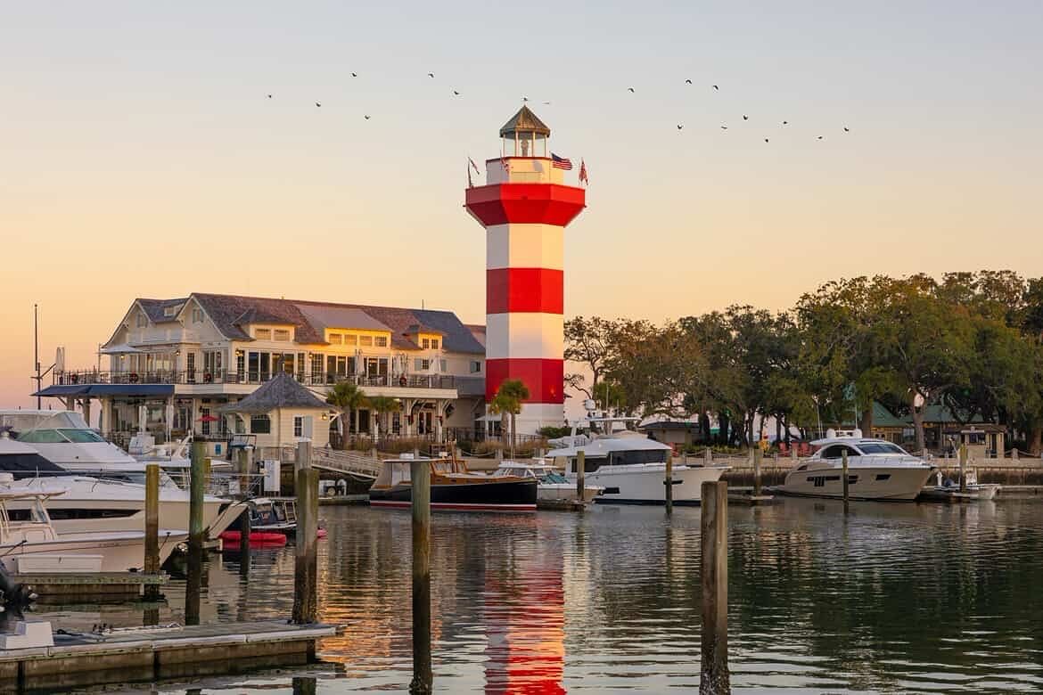 The iconic red and white Harbour Town Lighthouse stands tall over the marina filled with boats at sunset. Located in Sea Pines on Hilton Head Island, this landmark offers stunning harbor views and a small coastal museum inside. It’s one of the most photographed spots on the island.