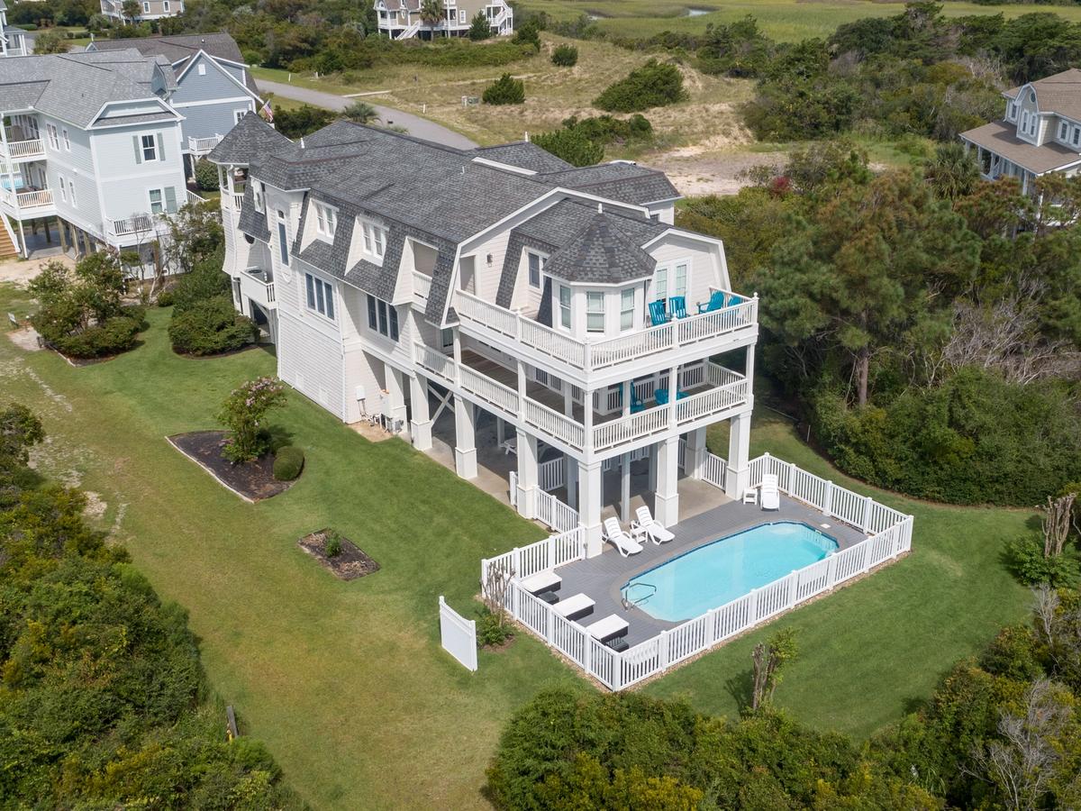 Large white home in Holden Beach with private pool surrounded with white fence