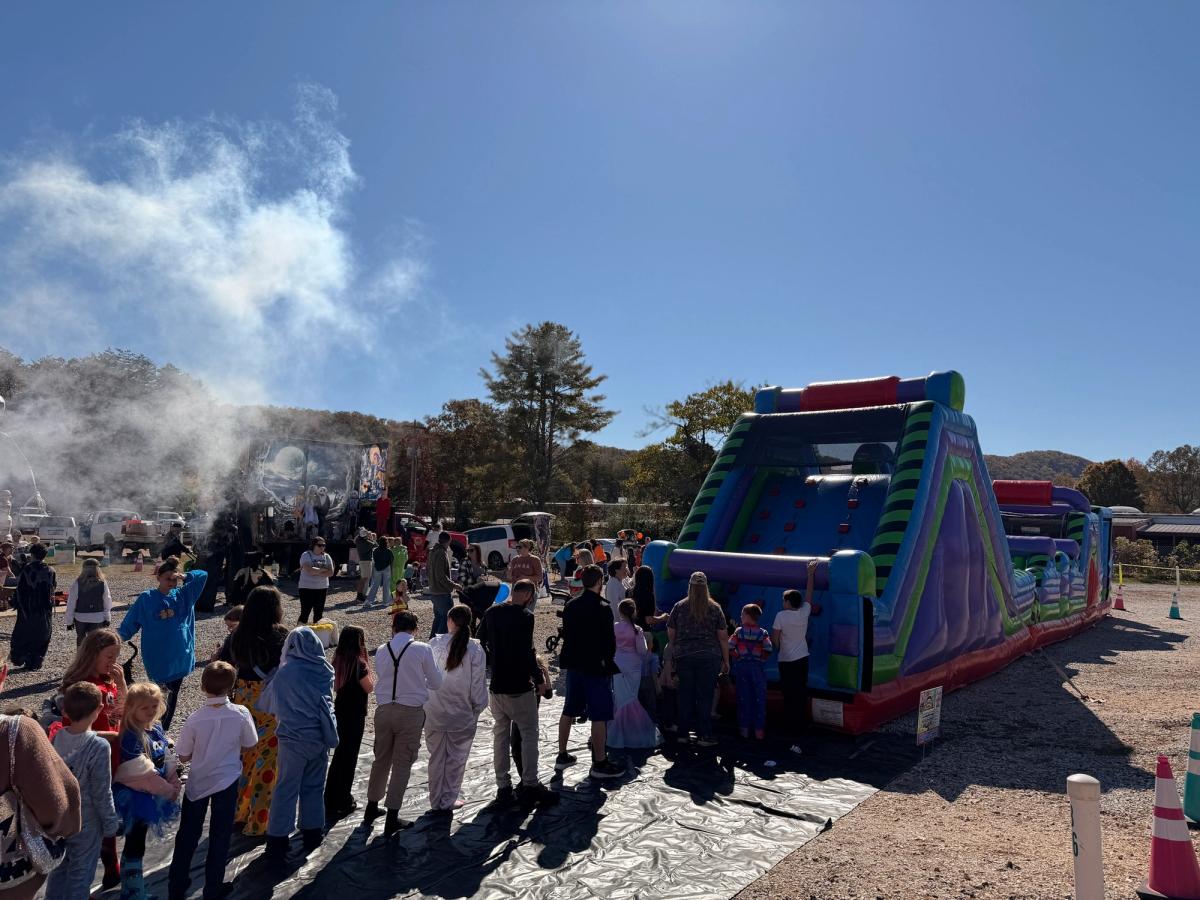 Families line up near inflatable attractions during a fun event at Swan Drive-In Theater & Diner in Blue Ridge. This local favorite combines classic drive-in movies, food, and family-friendly entertainment.