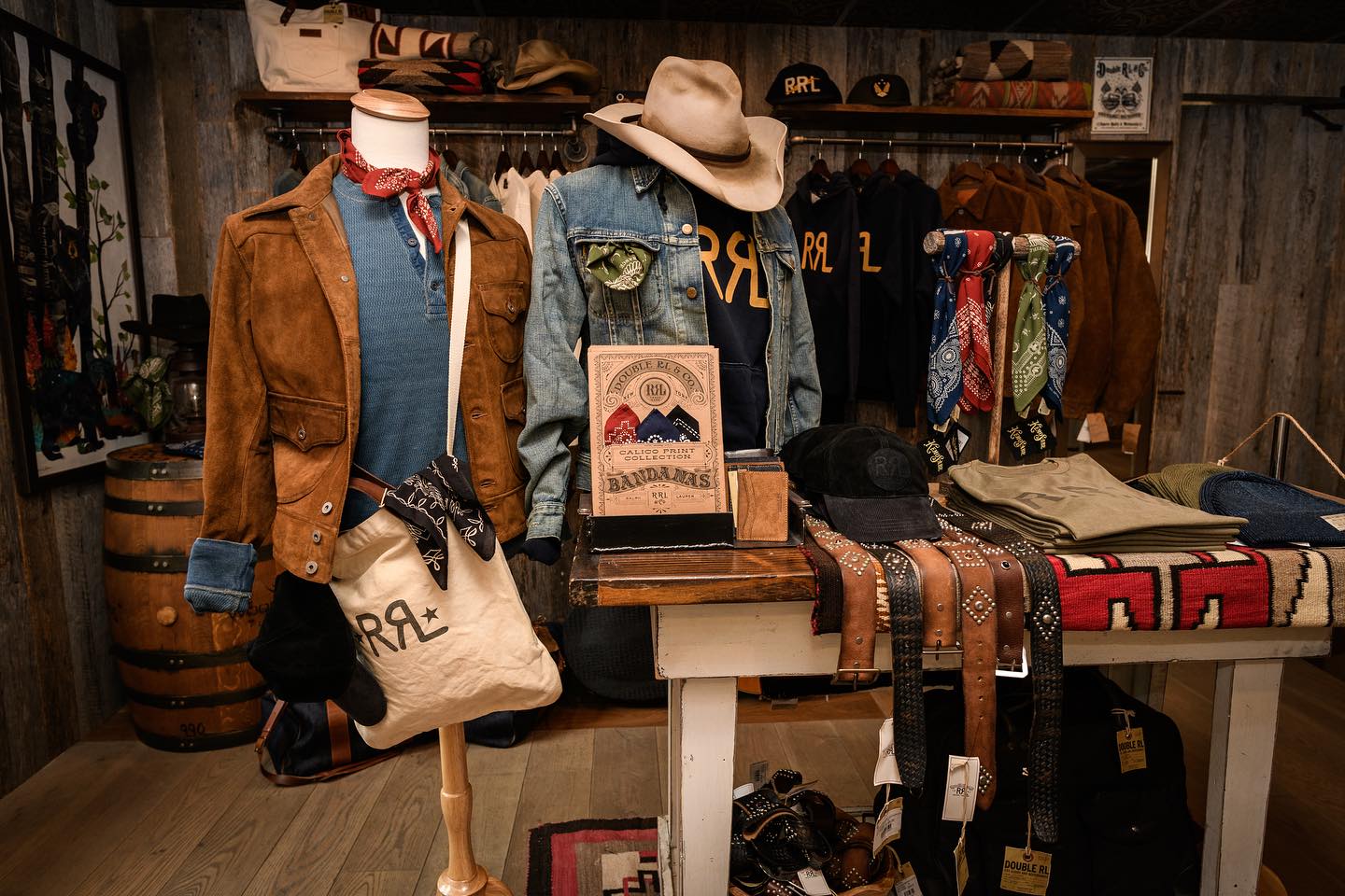 A rustic display inside Kemo Sabe shows Western-style jackets, hats, belts, and bandanas. The store is known for its classic cowboy fashion and custom hats. It’s a popular shopping stop in Jackson Hole.