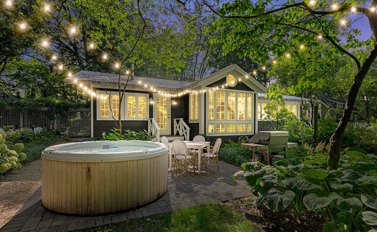 Cozy Leo Cottage vacation rental with private hot tub, outdoor patio, and wooded surroundings