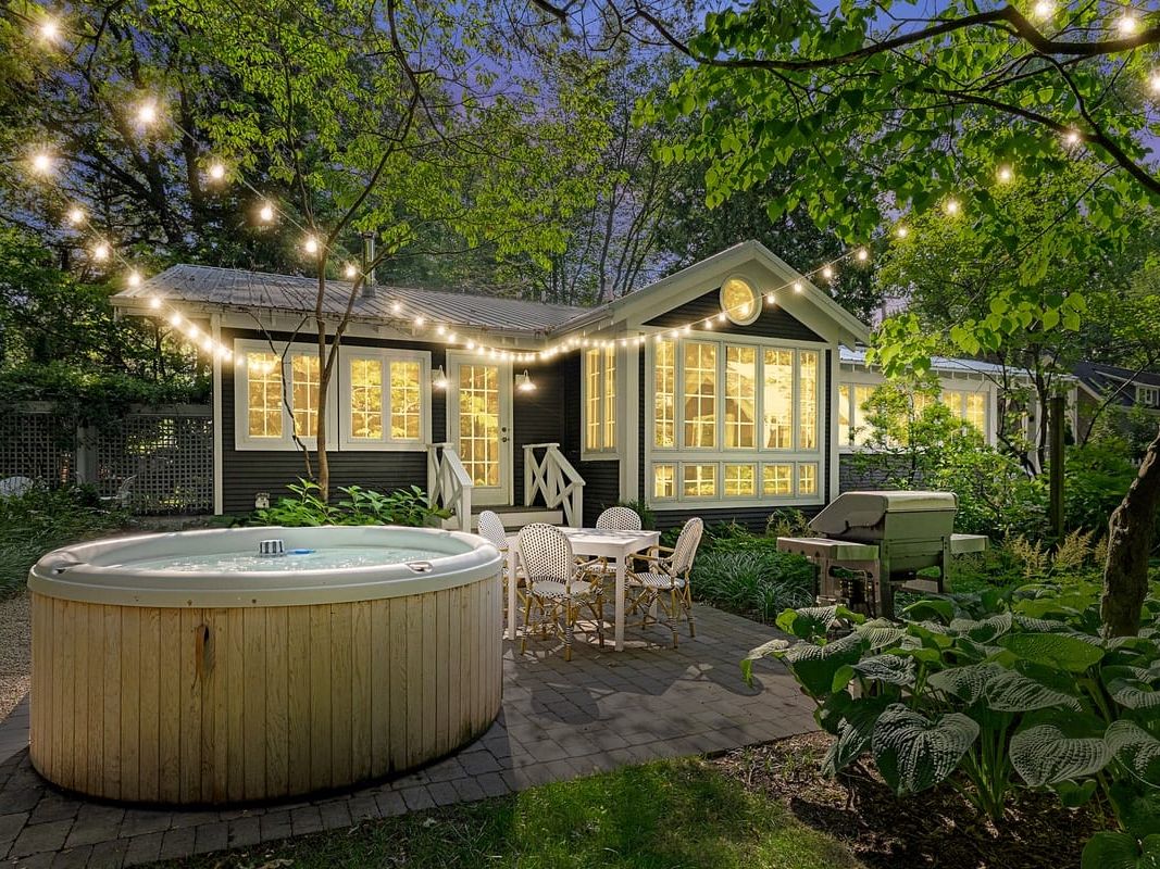 Cozy Leo Cottage vacation rental with private hot tub, outdoor patio, and wooded surroundings