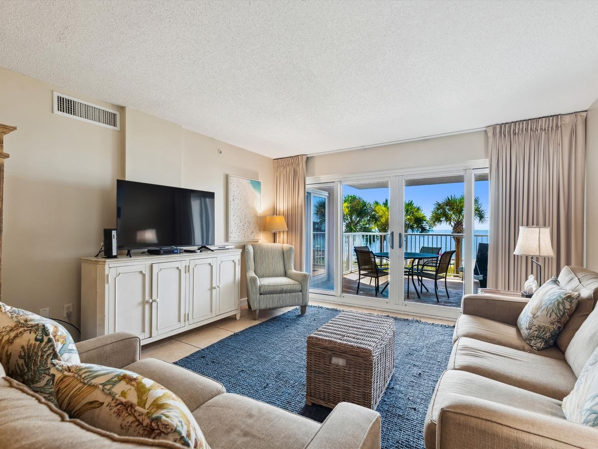 A shaded balcony with palm-tree views invites you to unwind while watching gentle waves roll onto the shore. The setup is simple and peaceful, perfect for morning coffee or sunset watching.
