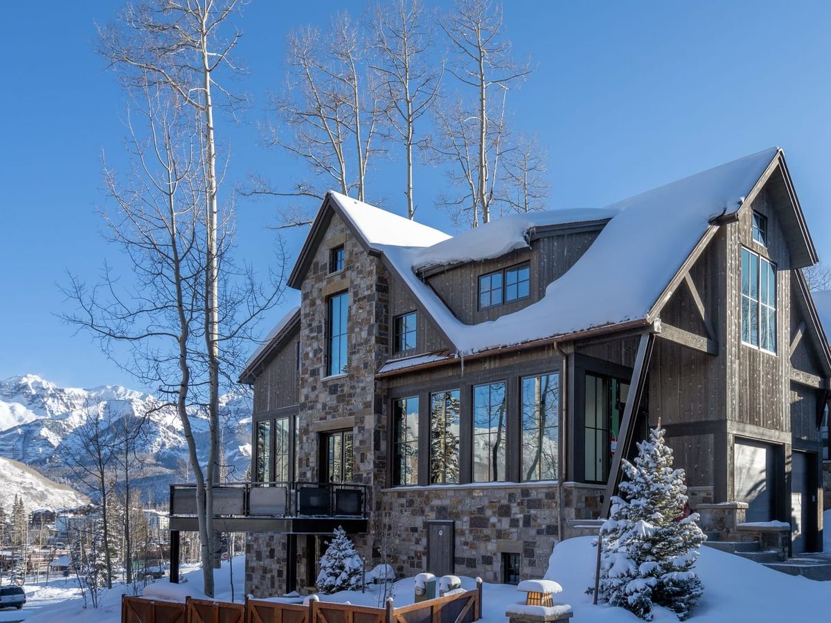 This stunning log cabin sits among tall aspens with views of rugged mountain ranges. Inside, a roaring fireplace and timber-beamed ceilings create a warm, welcoming atmosphere ideal for ski season getaways.