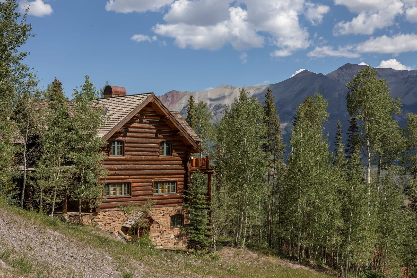 A grand luxury lodge tucked into the forest, with incredible mountain views and a rustic-chic design. Perfect for large gatherings, it combines elegance and adventure with open living spaces and outdoor hot tubs.