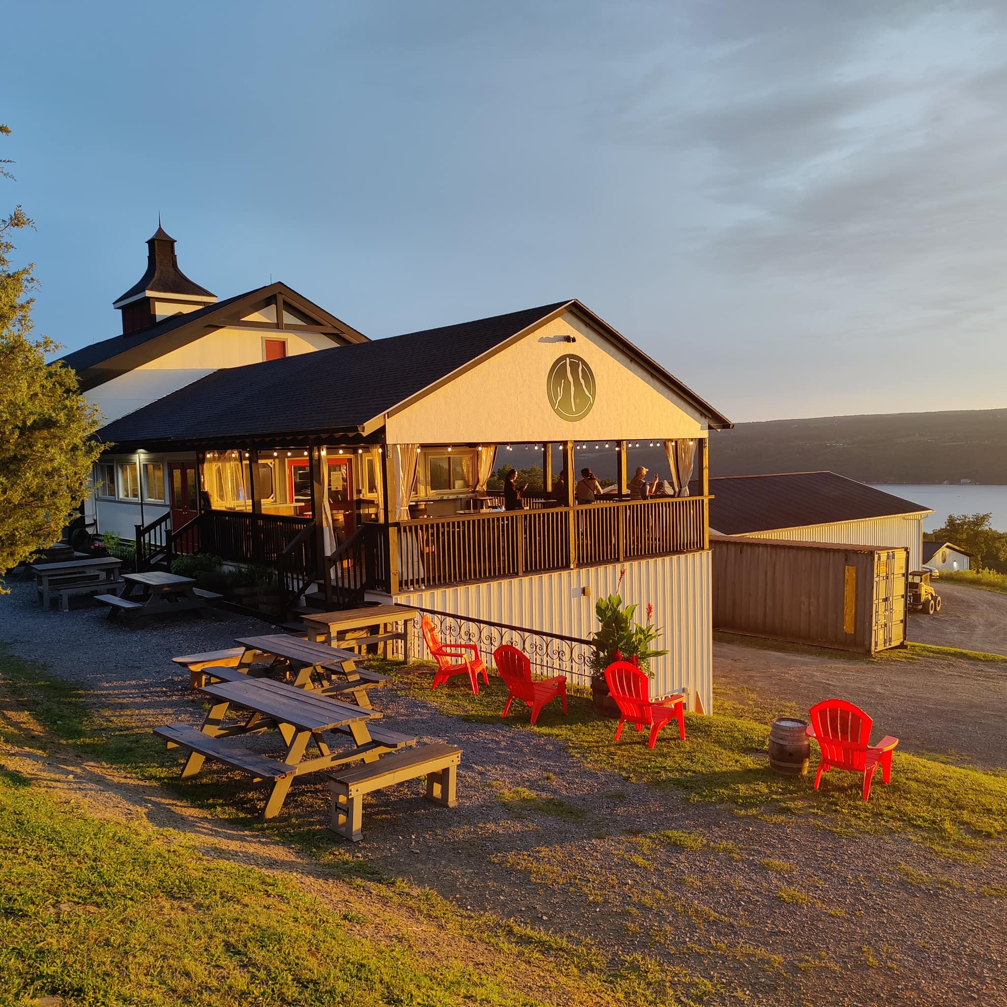 Guests gather outside Finger Lakes Distilling, enjoying drinks at picnic tables with open views of the rolling countryside. The relaxed setting makes it a popular stop for tasting local spirits in the Finger Lakes.