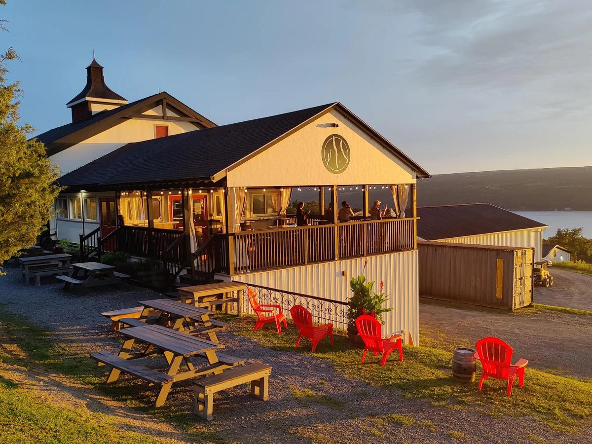 Guests gather outside Finger Lakes Distilling, enjoying drinks at picnic tables with open views of the rolling countryside. The relaxed setting makes it a popular stop for tasting local spirits in the Finger Lakes.