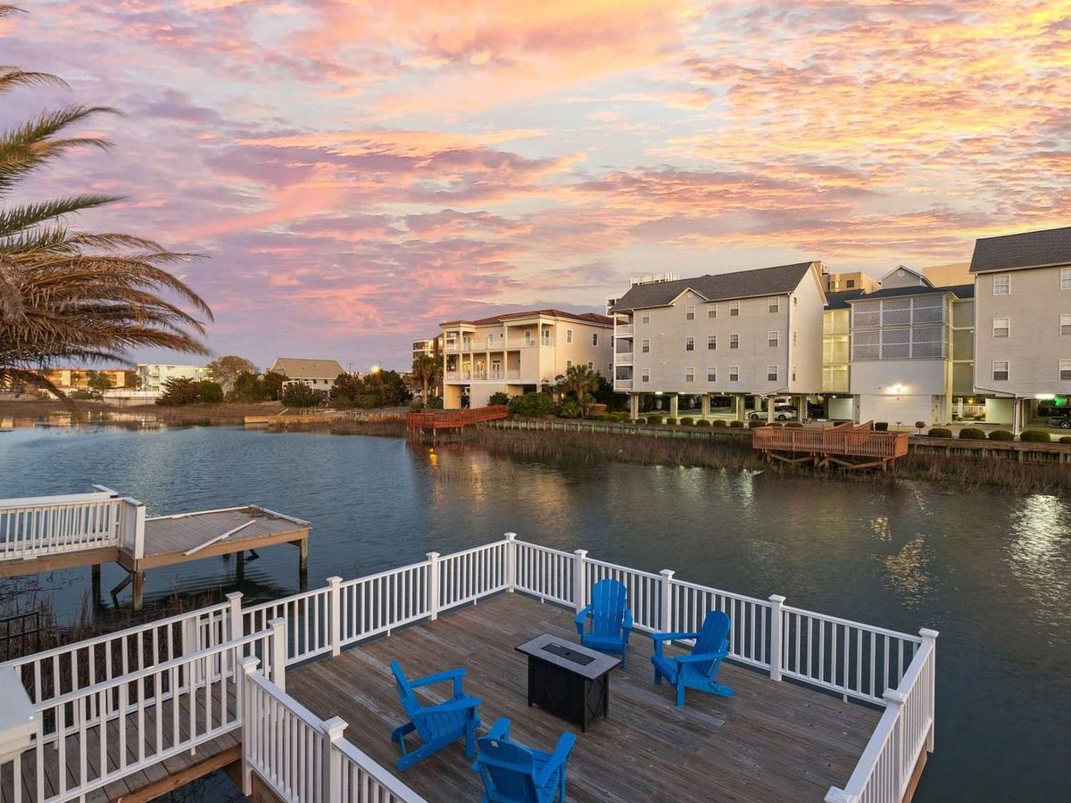 Nestled by the channel, this charming home features a softly lit pool area surrounded by modern lounge chairs. It’s the kind of place where you can sip a drink at sunset and watch the reflections dance on the water.