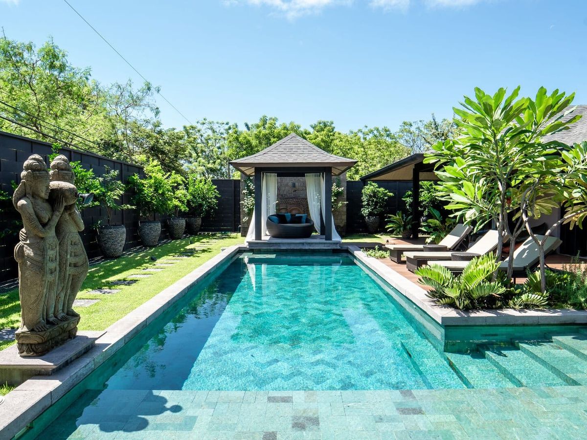 Soul House features a private tropical swimming pool surrounded by lush greenery, sun loungers, and a shaded poolside cabana. The peaceful outdoor space offers plenty of privacy for a relaxing stay in Tamarindo, Costa Rica.