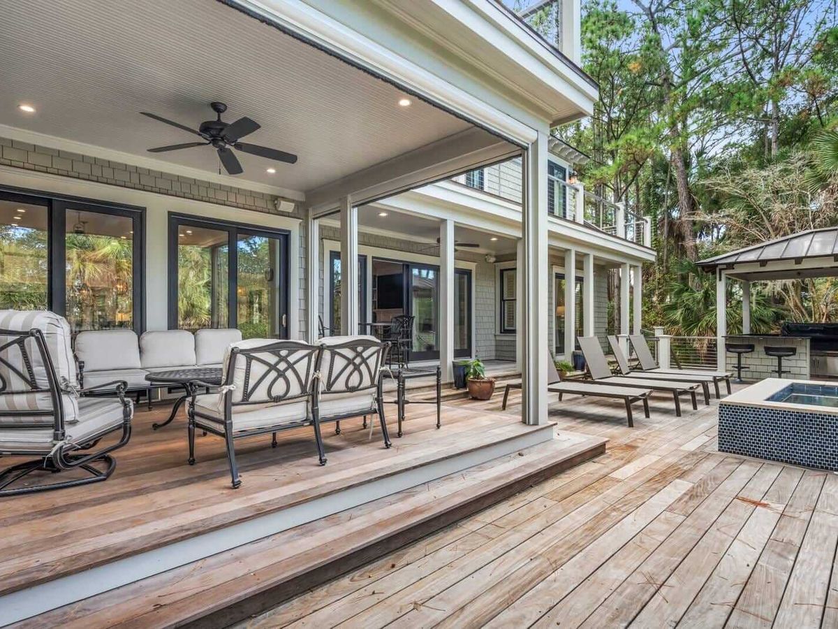 This deck has everything from lounge chairs, outdoor seating, a covered bar, and a bubbling spa. It's built for unwinding after beach days.