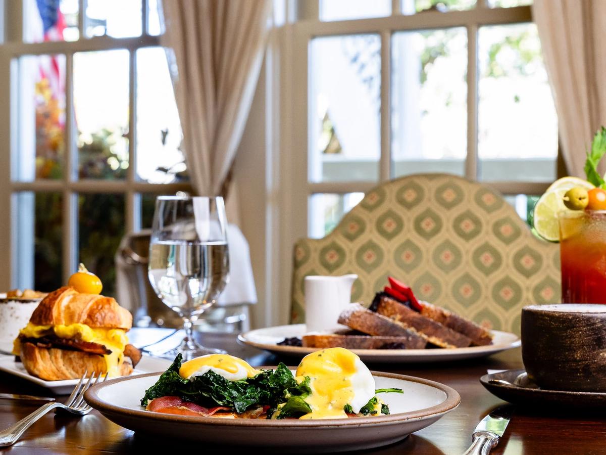 A perfectly grilled steak served with roasted mushrooms and crispy potatoes on a stylish plate. A glass of red wine sits nearby, adding to the upscale dining atmosphere. Madison’s Restaurant & Wine Garden is known for refined dishes and a relaxing wine garden setting.