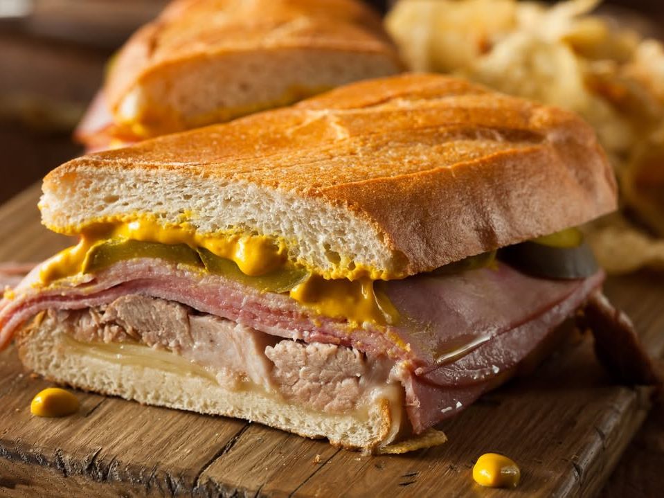 A classic Cuban sandwich stacked with pork, ham, pickles, mustard, and cheese on grilled Cuban bread. Crispy, tangy, and packed with bold flavors in every bite.