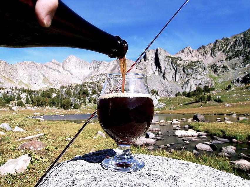 A rich, dark beer is poured into a glass against the backdrop of Montana’s rugged mountain peaks. Beehive Basin Brewery blends local flavors with adventure, making it a must-stop for craft beer lovers.
