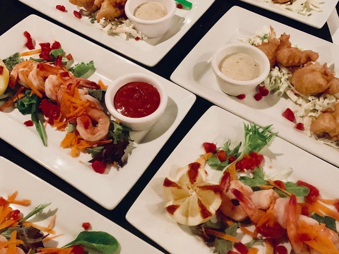 Elegant seafood and shrimp appetizers beautifully plated with dipping sauces at Aspen Grille. This Myrtle Beach steakhouse blends upscale dining with Southern charm.