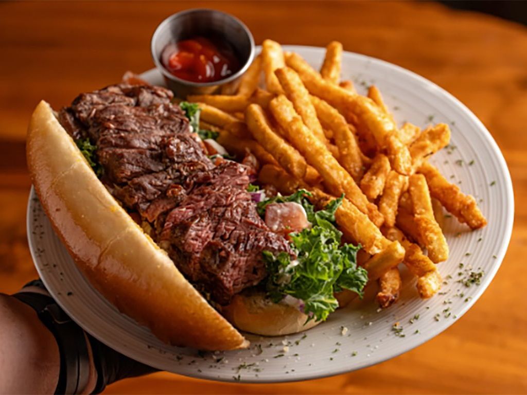 A table filled with vibrant dishes including grilled meats, rice, vegetables, and small plates ready to share. The variety of flavors reflects the lively atmosphere of Brazilian-style dining. Restaurants like this offer a fun experience where guests can enjoy multiple dishes in one meal.