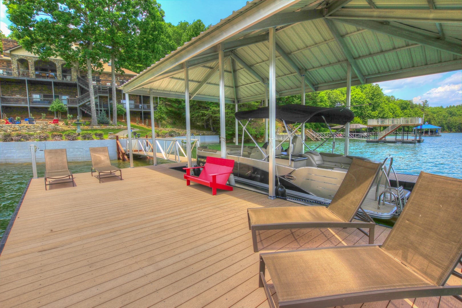 The private dock at Blue Ridge Lakeside Chateau offers a relaxing lakeside setup with lounge chairs and a covered boat slip. This waterfront property is perfect for swimming, boating, and enjoying peaceful mountain lake views.