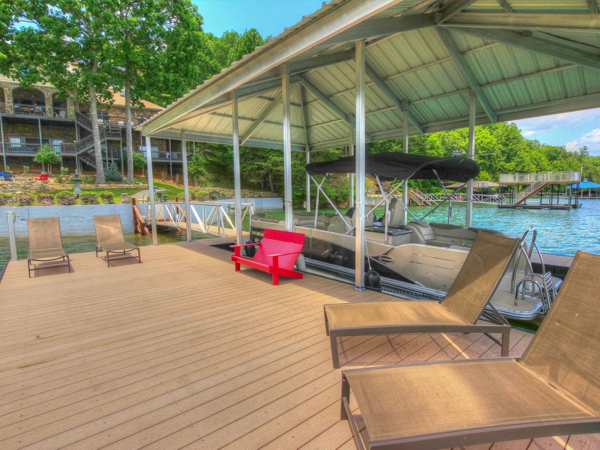 The private dock at Blue Ridge Lakeside Chateau offers a relaxing lakeside setup with lounge chairs and a covered boat slip. This waterfront property is perfect for swimming, boating, and enjoying peaceful mountain lake views.