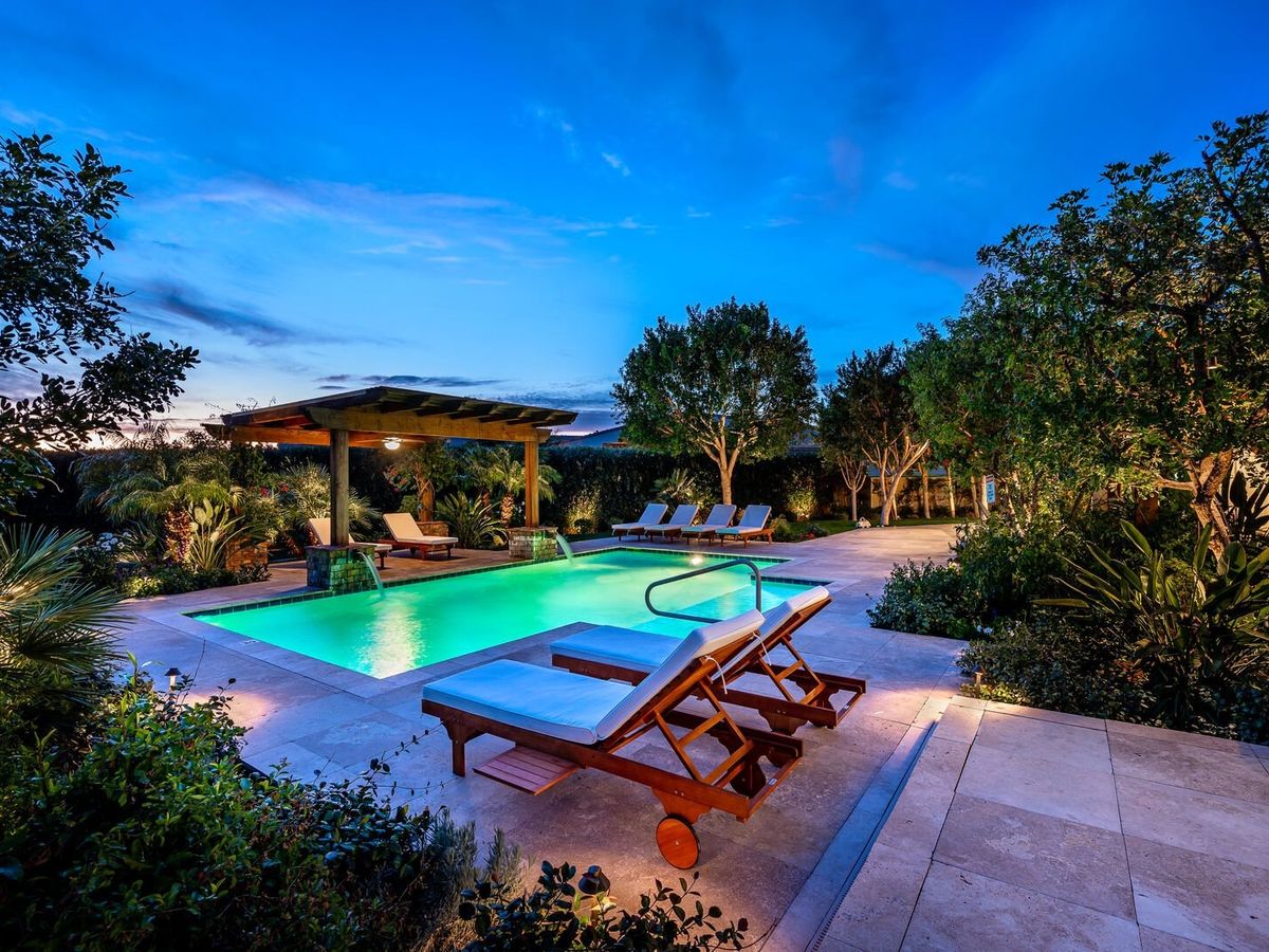 Scottsdale, AZ Vacation Rentals Back Yard at Night with Pool and Lounge Chairs