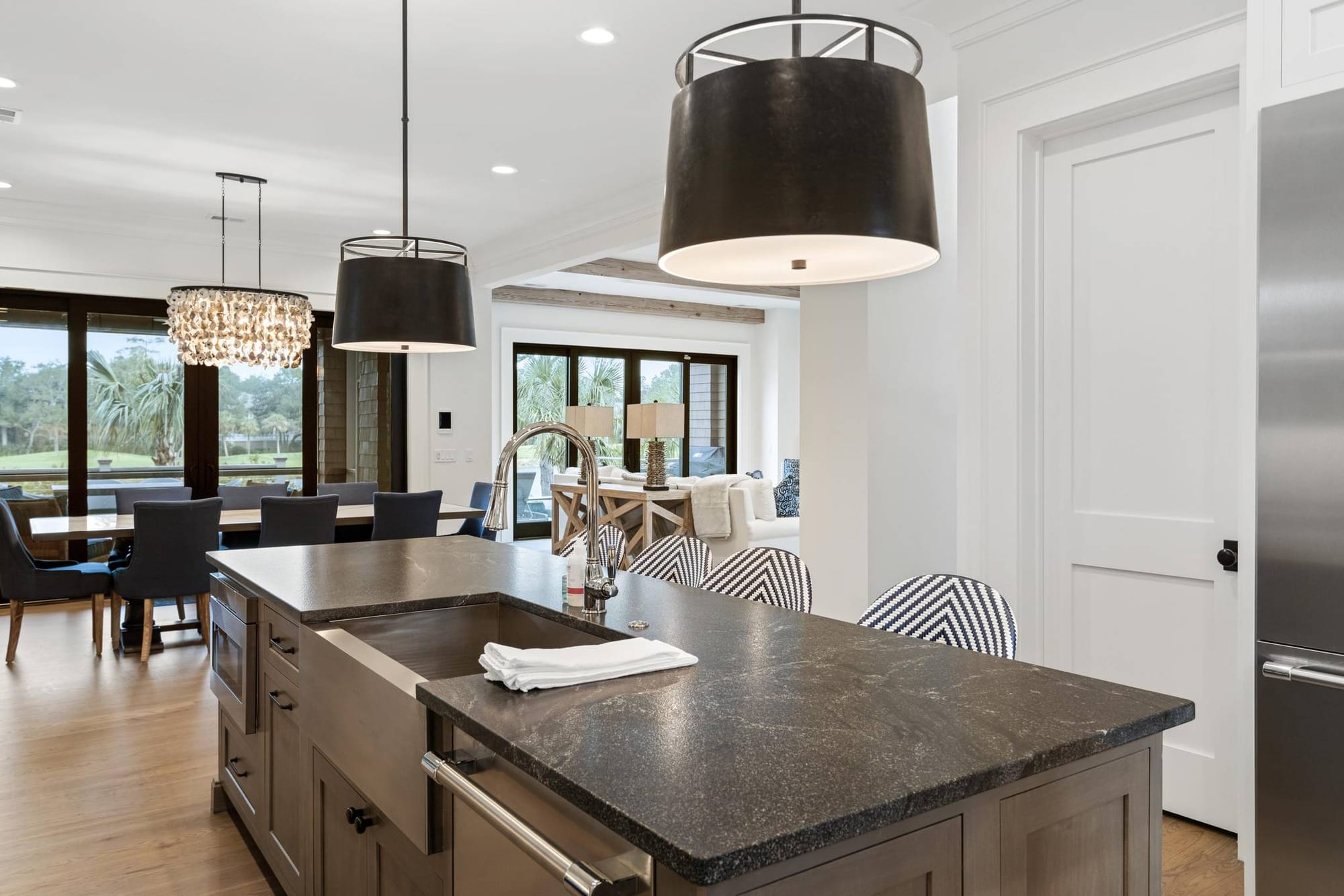 This bright, open kitchen features a large island, modern pendant lights, and high-end finishes perfect for group meals. The space flows into the dining and living areas, making it easy to gather, cook, and relax together during your stay.