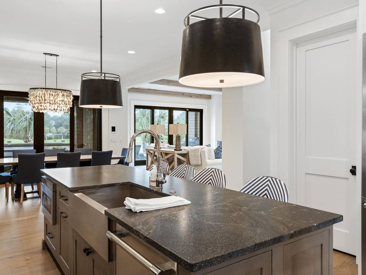 This bright, open kitchen features a large island, modern pendant lights, and high-end finishes perfect for group meals. The space flows into the dining and living areas, making it easy to gather, cook, and relax together during your stay.