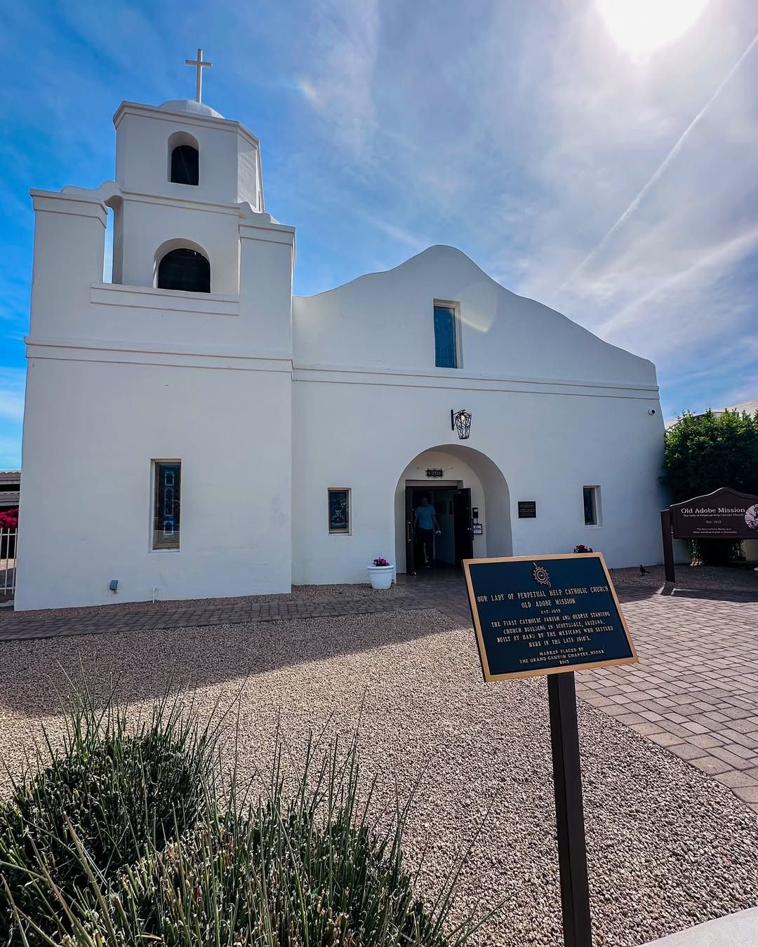 The Old Adobe Mission in Scottsdale stands with white stucco walls and a simple bell tower. This historic church is one of the oldest buildings in the area and a peaceful place to visit in Old Town.