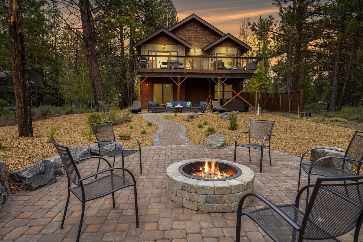 This spacious luxury cabin is built for gatherings, with a beautiful outdoor firepit overlooking the forest and river. The upper deck features ample seating for dining and lounging while enjoying sunset views. Inside, vaulted ceilings and large living areas make it ideal for family reunions or group retreats.