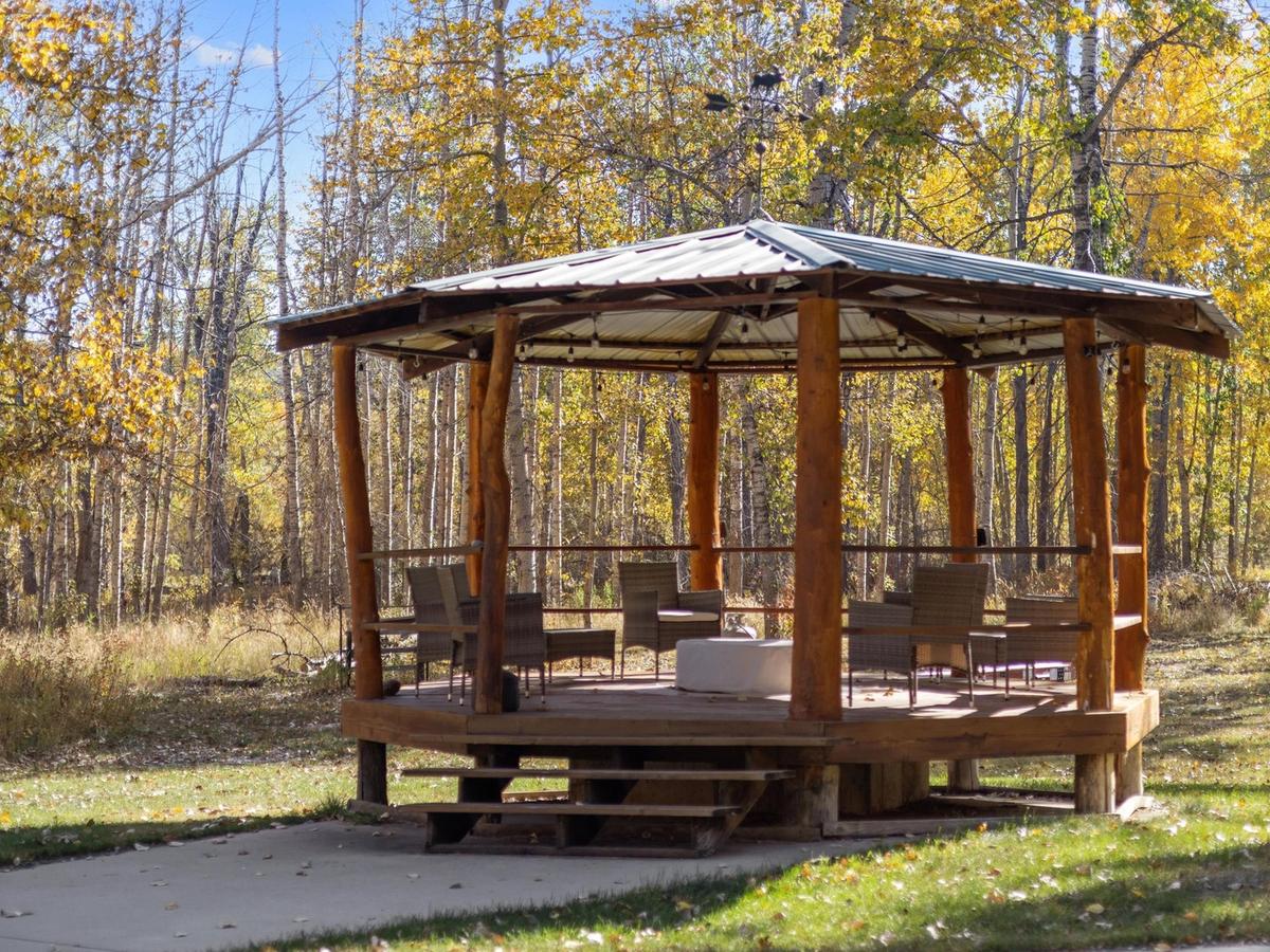 Veranda with chairs and fireplace surrounded by fall foliage in mt