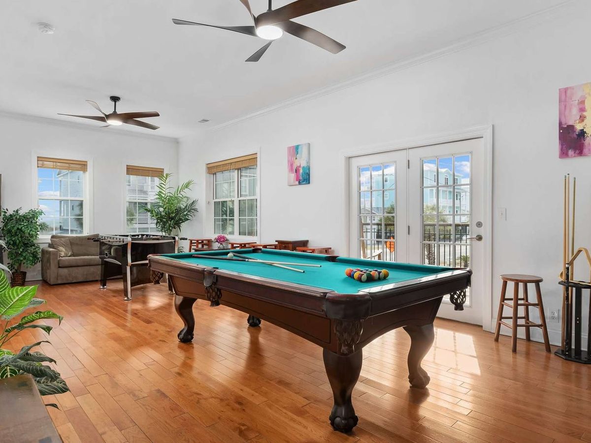 Game room with a full-size pool table offers fun indoor entertainment for guests of all ages. Large windows and comfortable seating create a bright space perfect for friendly competitions and family time.