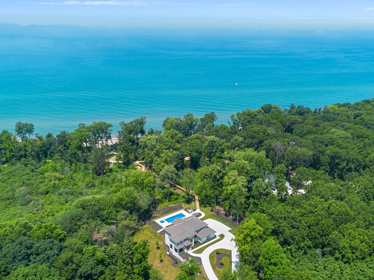 Aerial view of a secluded home surrounded by forest with a clear blue pool and sweeping views of the ocean. The scene reflects a peaceful escape where personalized itineraries help you explore both nature and luxury.