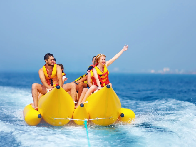 A group of friends laugh and hold on tight as their banana boat speeds across the sparkling ocean. It’s the perfect mix of sunshine, excitement, and tropical fun in the Bahamas.