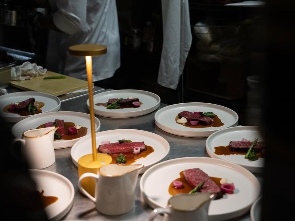 Modern fine dining plates being prepared in the kitchen at Kabooki Sushi Orlando. Artistic presentation meets Japanese fusion cuisine.