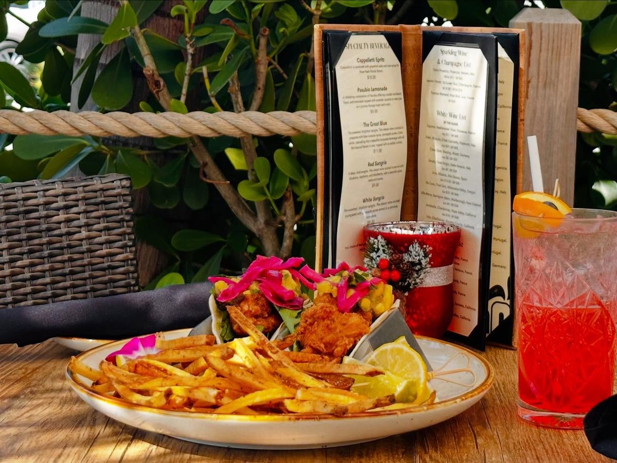 A beautifully plated seafood dish featuring grilled shrimp over mashed potatoes, served with a fresh green salad. The golden sear and creamy textures make it a local favorite for coastal dining.