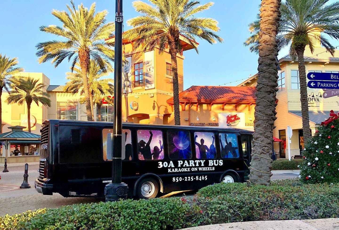 30A Party Bus parked near restaurants and shops along Scenic Highway 30A in Florida, offering karaoke and nightlife entertainment.