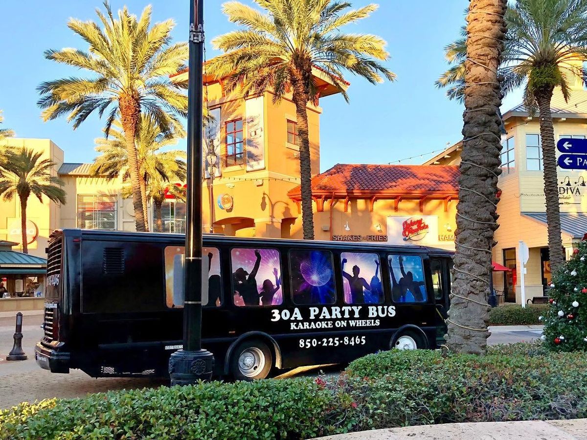 30A Party Bus parked near restaurants and shops along Scenic Highway 30A in Florida, offering karaoke and nightlife entertainment.